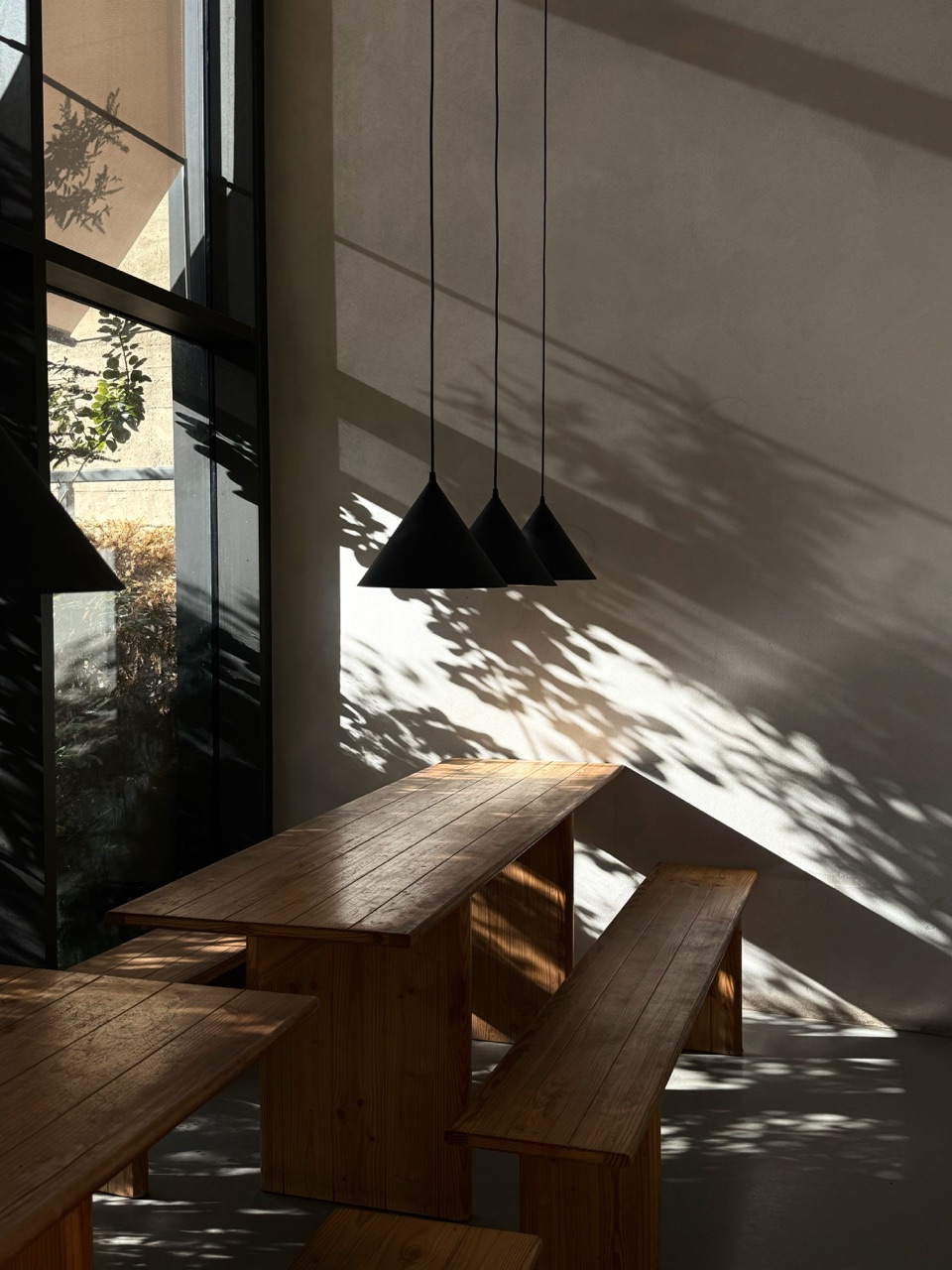 Wood dining table and pendant lights in a sunlit interior